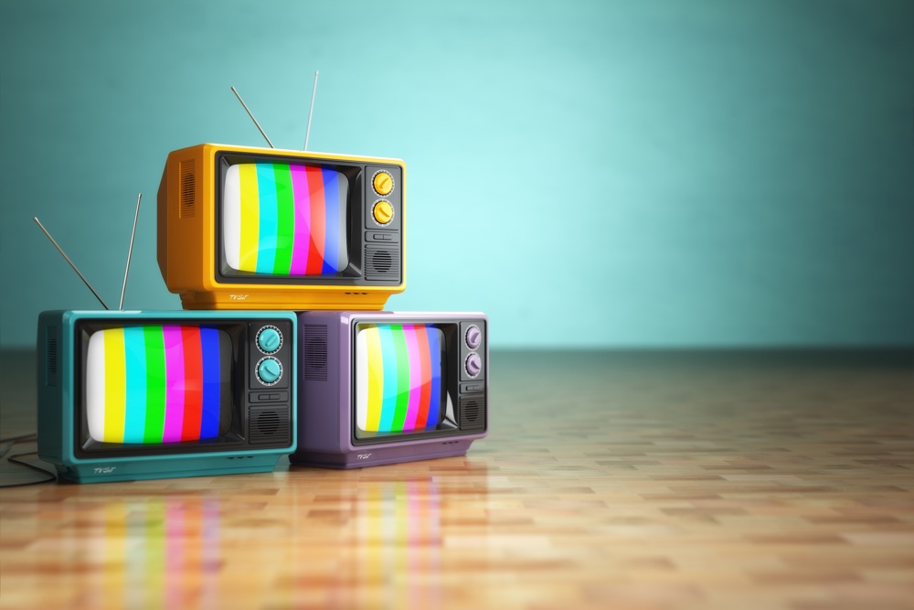 Vintage television concept. Stack of retro tv set on green background. 3d