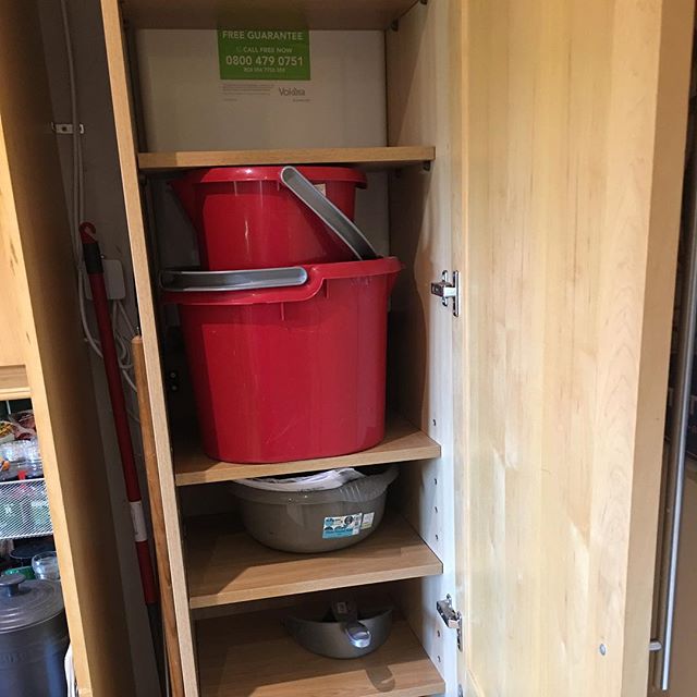shelving and storage space in a kitchen cupboard around the gas boiler
