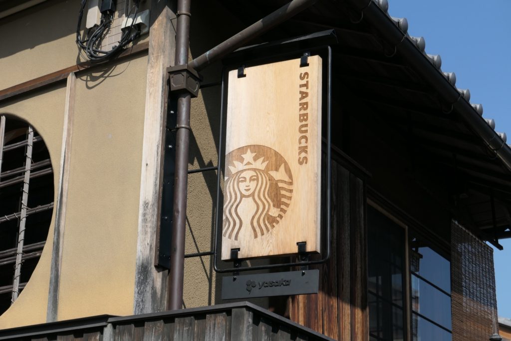 Close up of the signage outside a Starbucks in Kyoto that blends in with the local architectural style